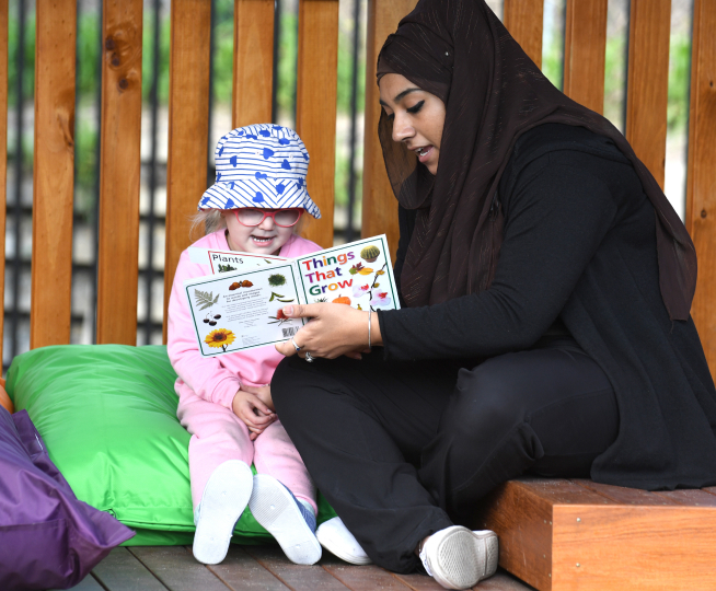 Teacher reading and interacting with a child - Evolving Minds Early Learning Wooloowin Qld